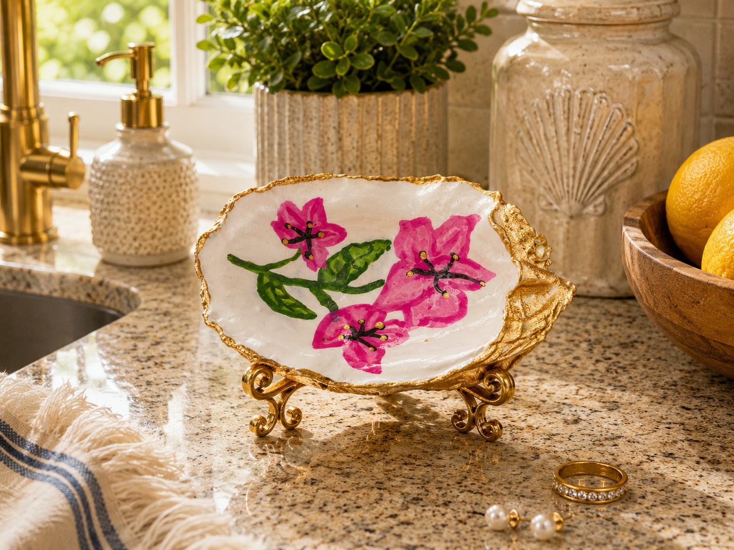 AI lifestyle flat lay of The Masters Azalea Keepsake gilded oyster shell trinket dish styled with candle, ring, and earrings — unique golf-inspired coastal gift