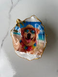 Hero shot of Golden Retriever Beach Day gilded oyster shell ring dish with gold paint edging, displayed on a gold stand