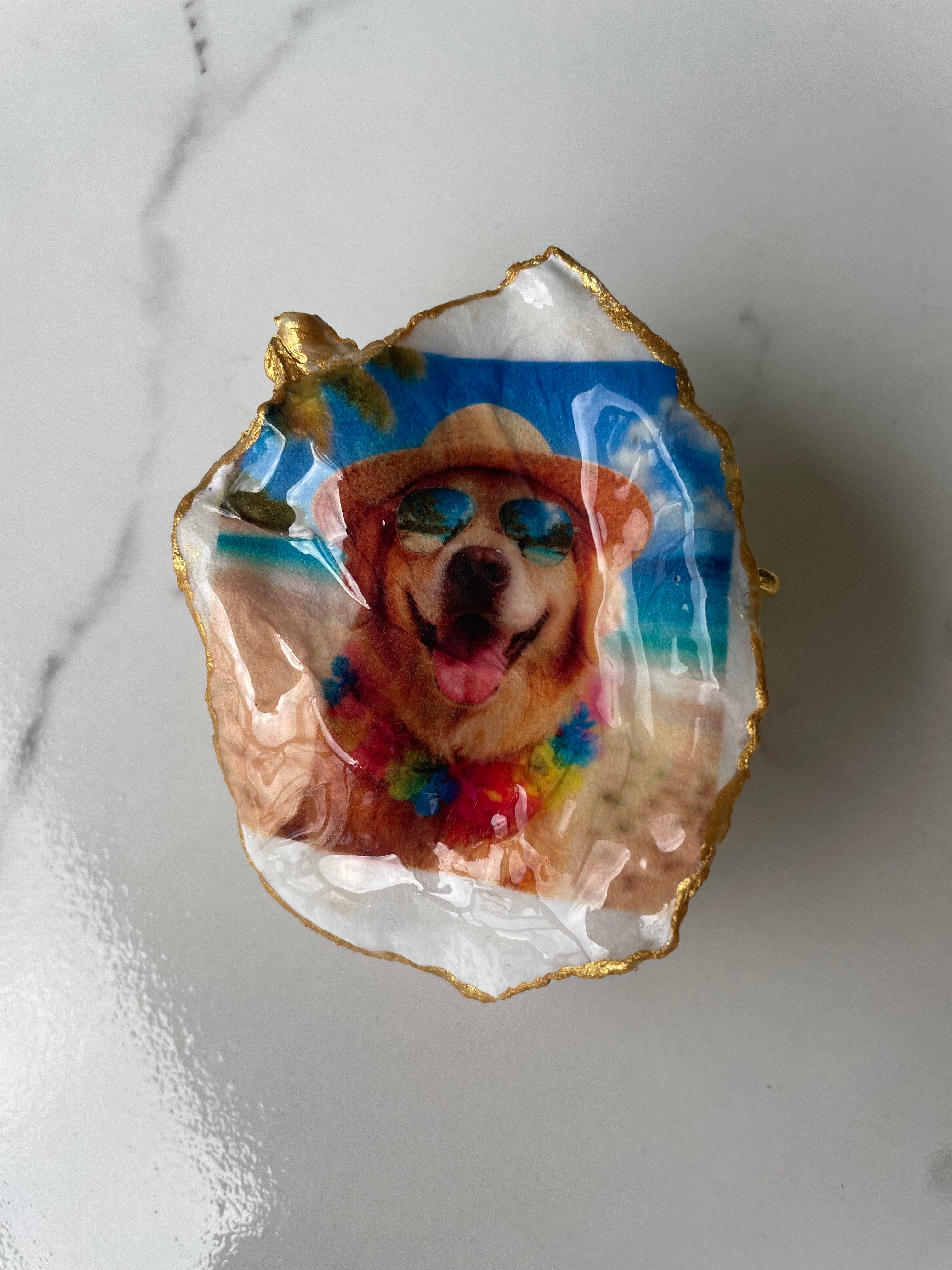 Hero shot of Golden Retriever Beach Day gilded oyster shell ring dish with gold paint edging, displayed on a gold stand