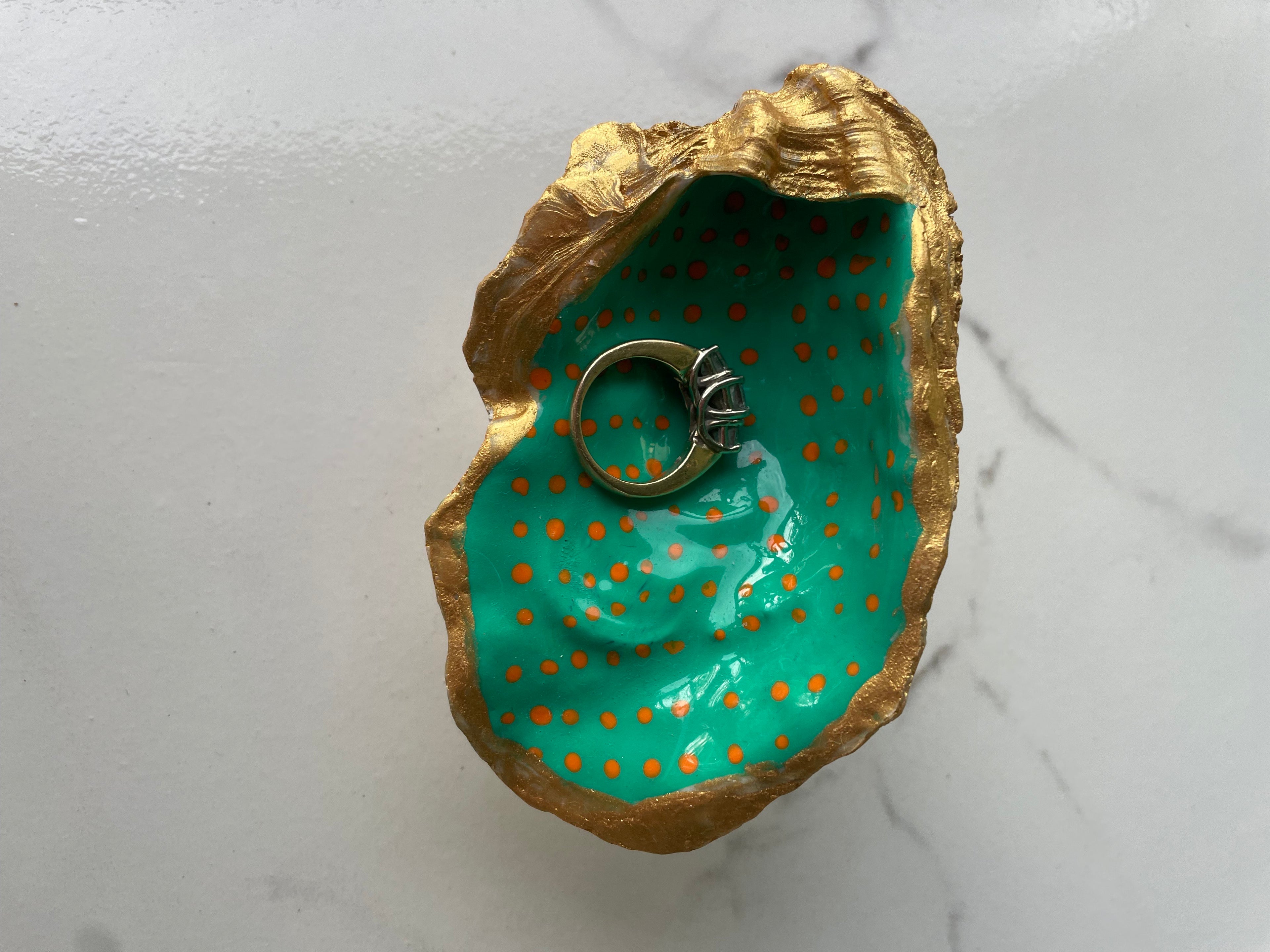 Teal Speckle gilded oyster shell trinket dish shown with ring to display size