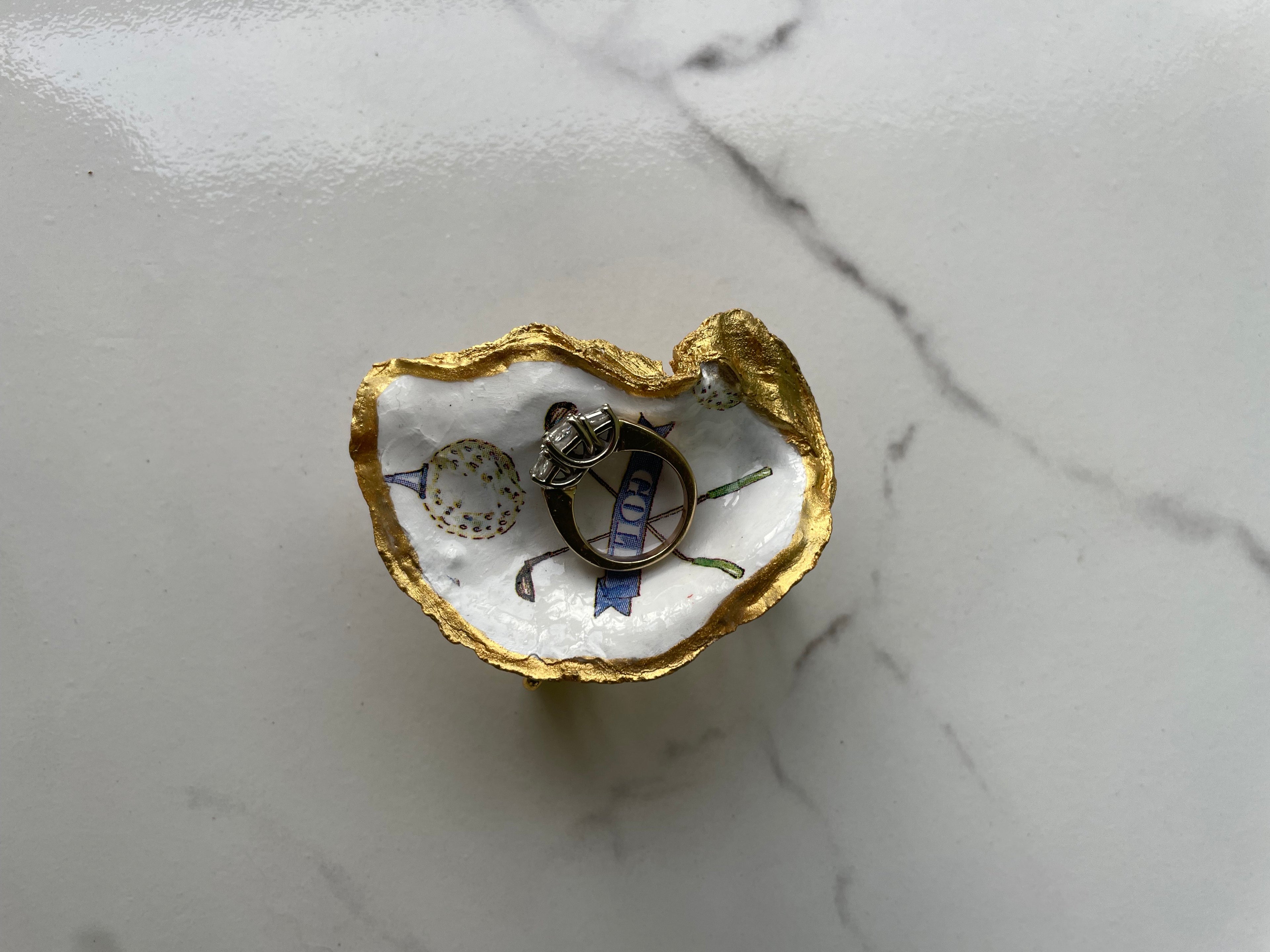 The 19th Hole Keepsake Classic Crossed Clubs Edition gilded oyster shell trinket dish shown with ring to display size