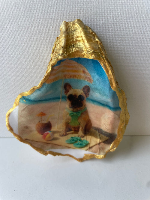 Frenchie Paradise gilded oyster shell ring dish propped up to show artwork — hand-painted French Bulldog beach scene with gold paint edging, handmade by The Golden Shoreline