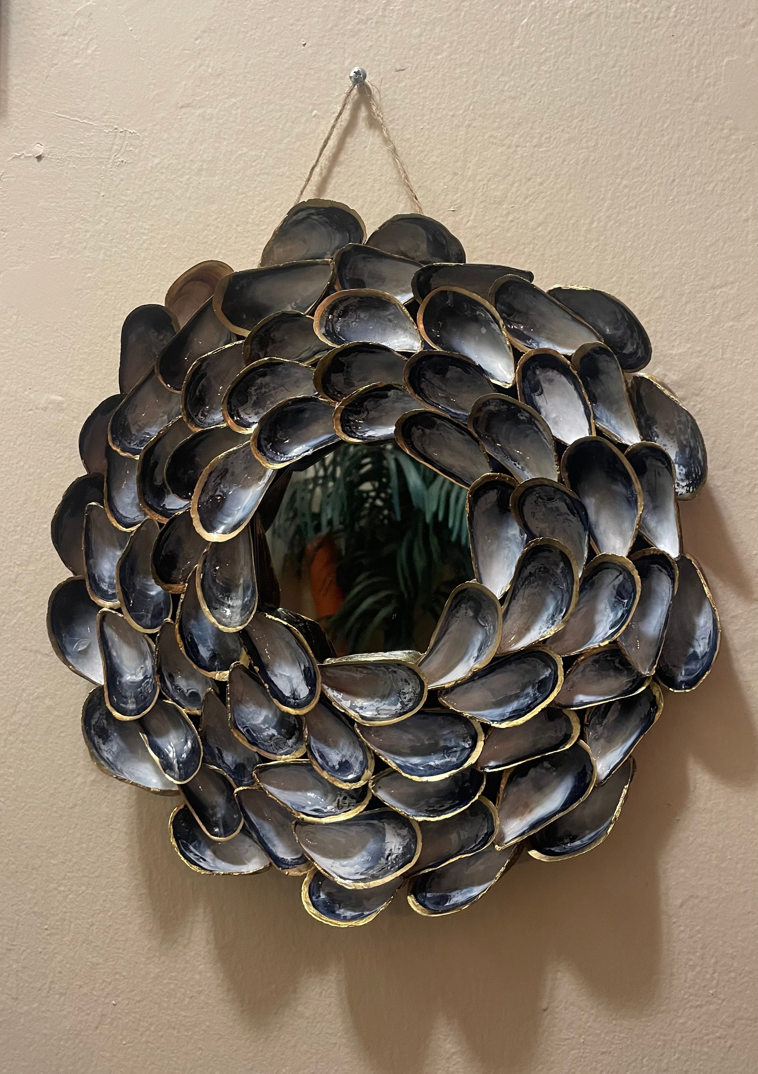 "Handcrafted mussel shell wreath with gold paint edges in deep charcoal, pearl, and midnight-blue tones — Midnight Tide by The Golden Shoreline"