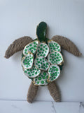 The Gilded Loggerhead Sea Glass Edition propped against white background — handcrafted sea turtle with green and gold paint shells and natural jute flippers by The Golden Shoreline