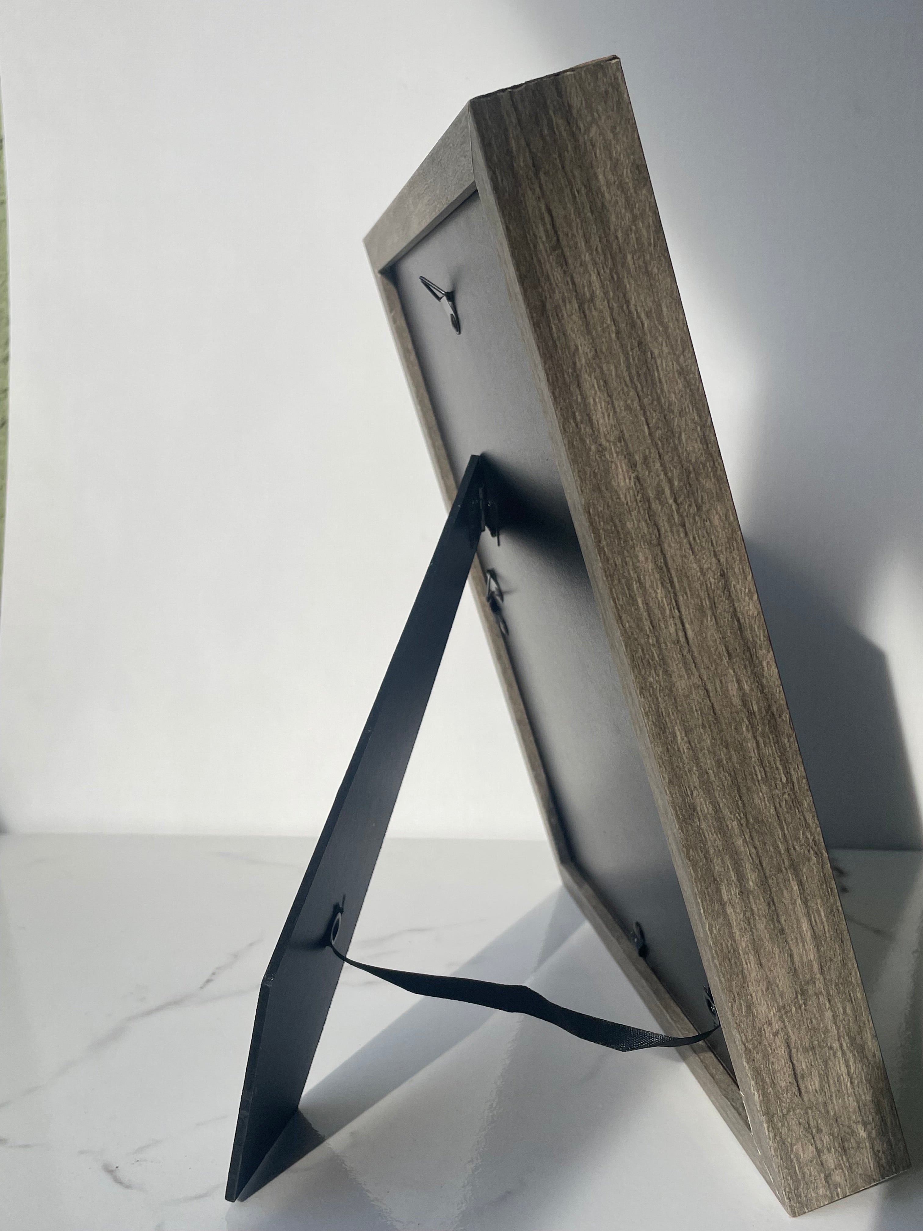 Back of rustic gray wood frame showing hanging hardware and easel stand, ready to hang or display on a shelf