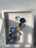 Coastal Cascade kintsugi shadow box wall art with hand-painted eggshells in coastal blues and gold paint, white shadow box frame
