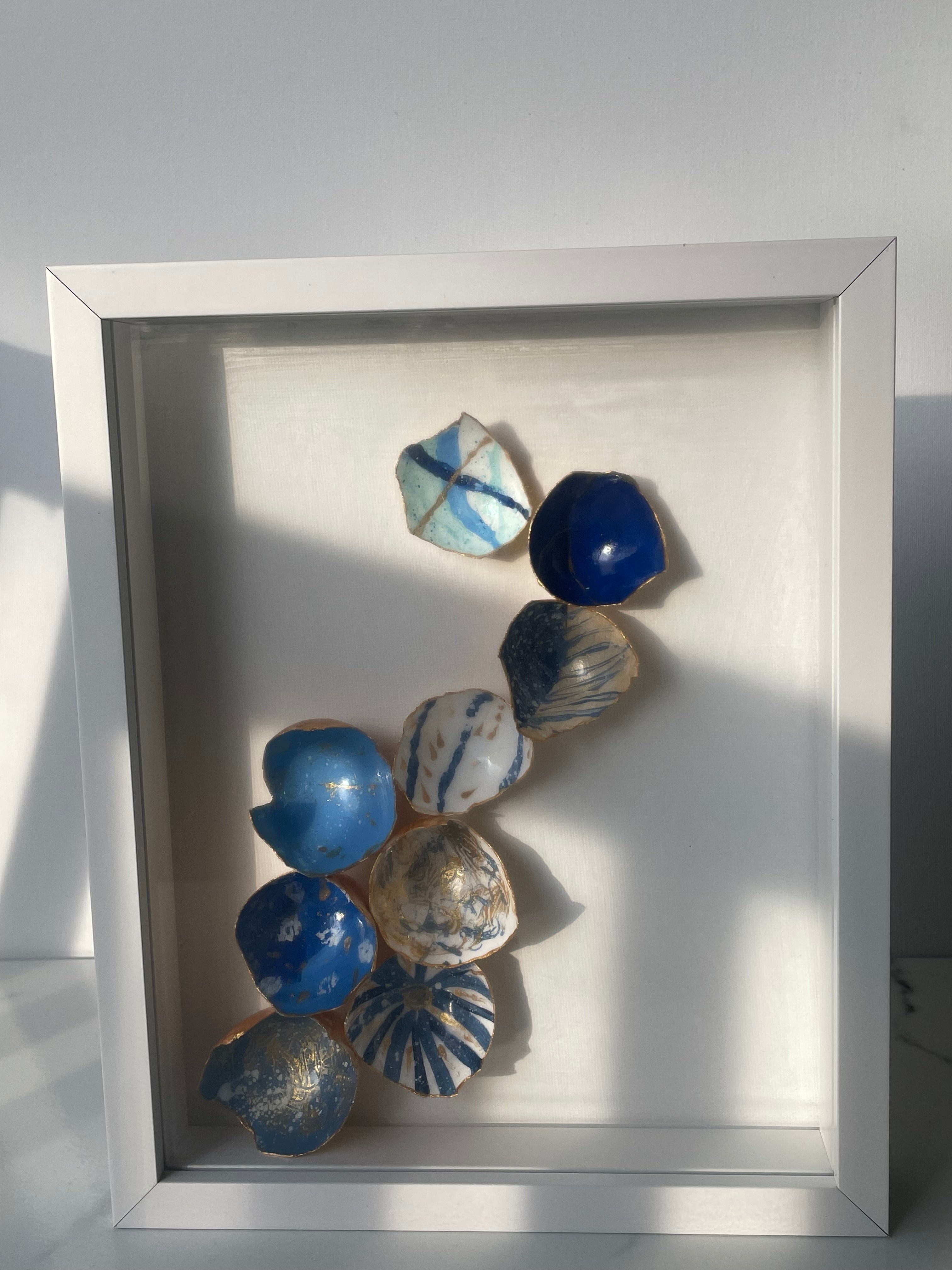 Coastal Cascade kintsugi shadow box wall art with hand-painted eggshells in coastal blues and gold paint, white shadow box frame
