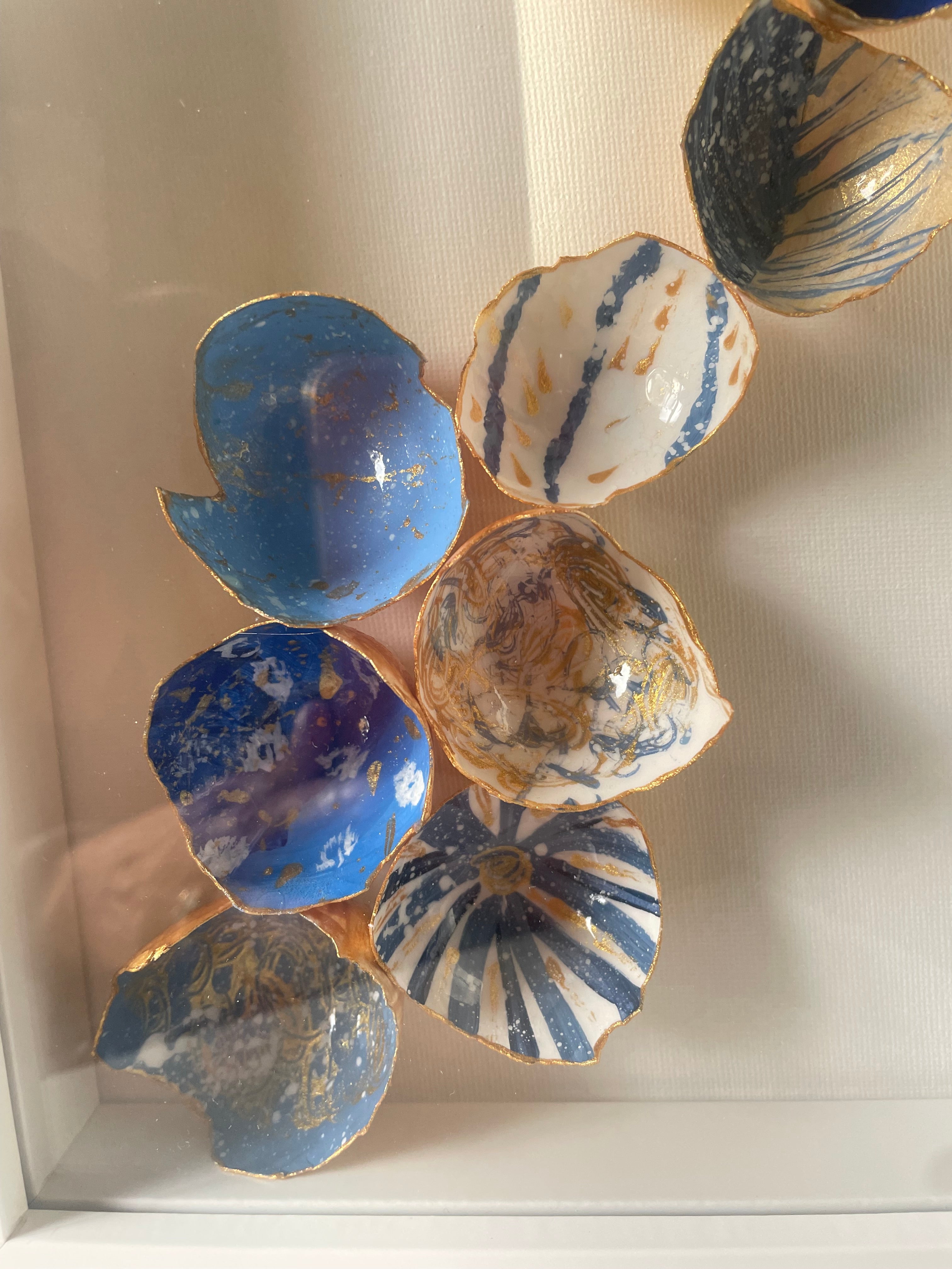 Close-up detail of hand-painted eggshells with gold paint edges in coastal blues, white, and earth tones — Coastal Cascade kintsugi wall art by The Golden Shoreline