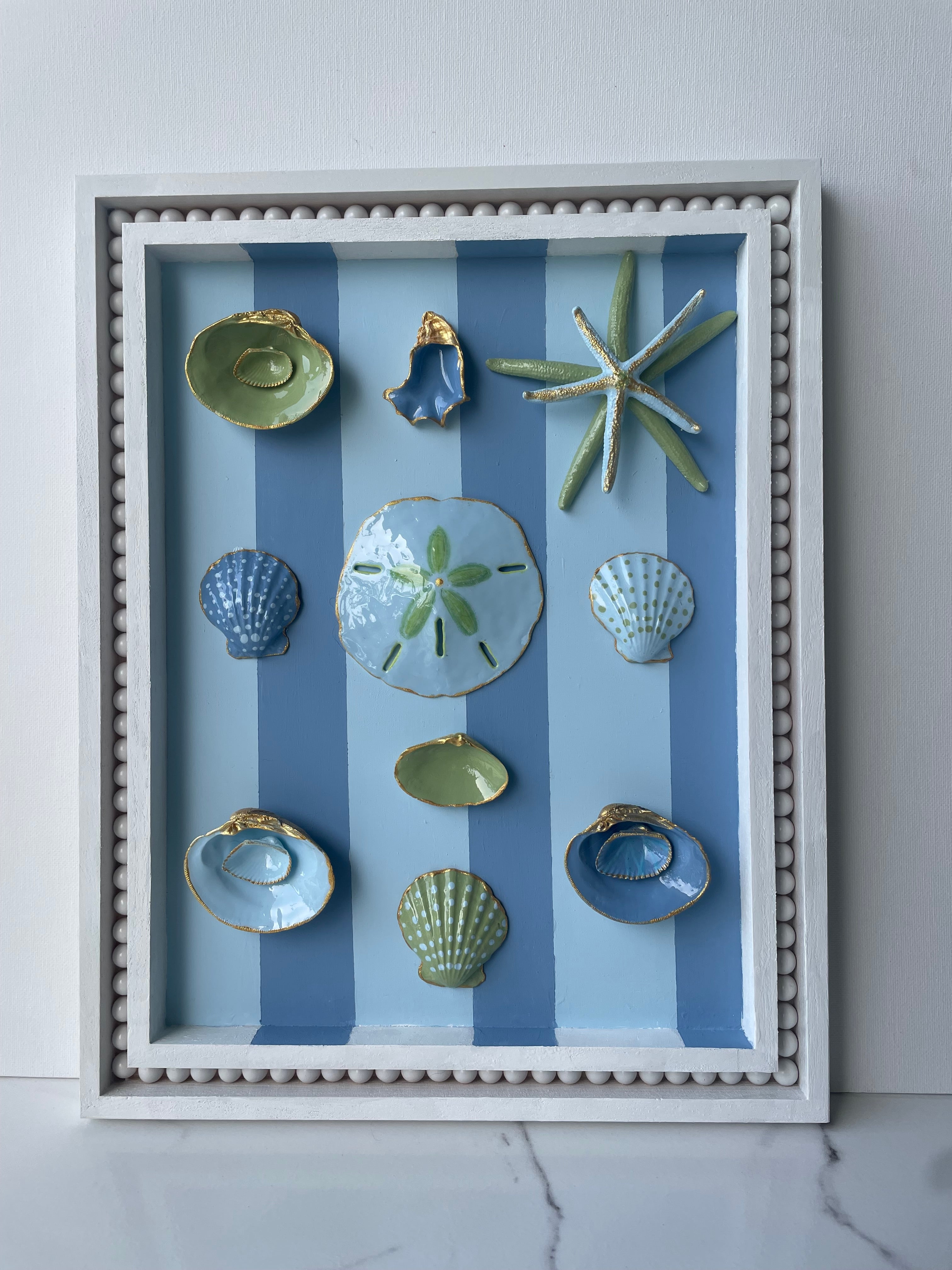 Original coastal wall art with oyster shells, starfish, and gold accents in an 11x14 wood frame"